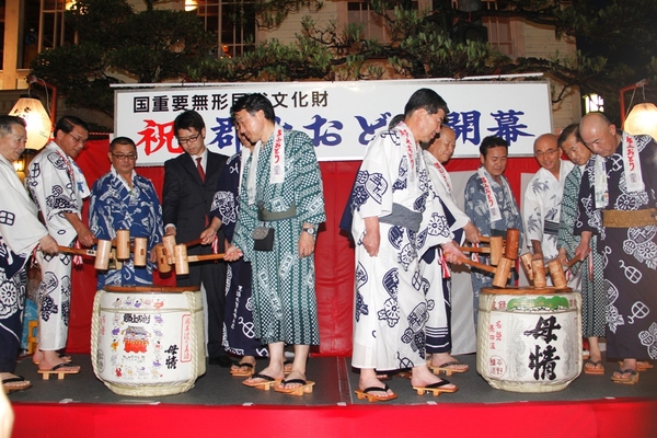 2つの酒樽の周りにそれぞれ6~7人の人が集まり鏡割をしようとしている写真