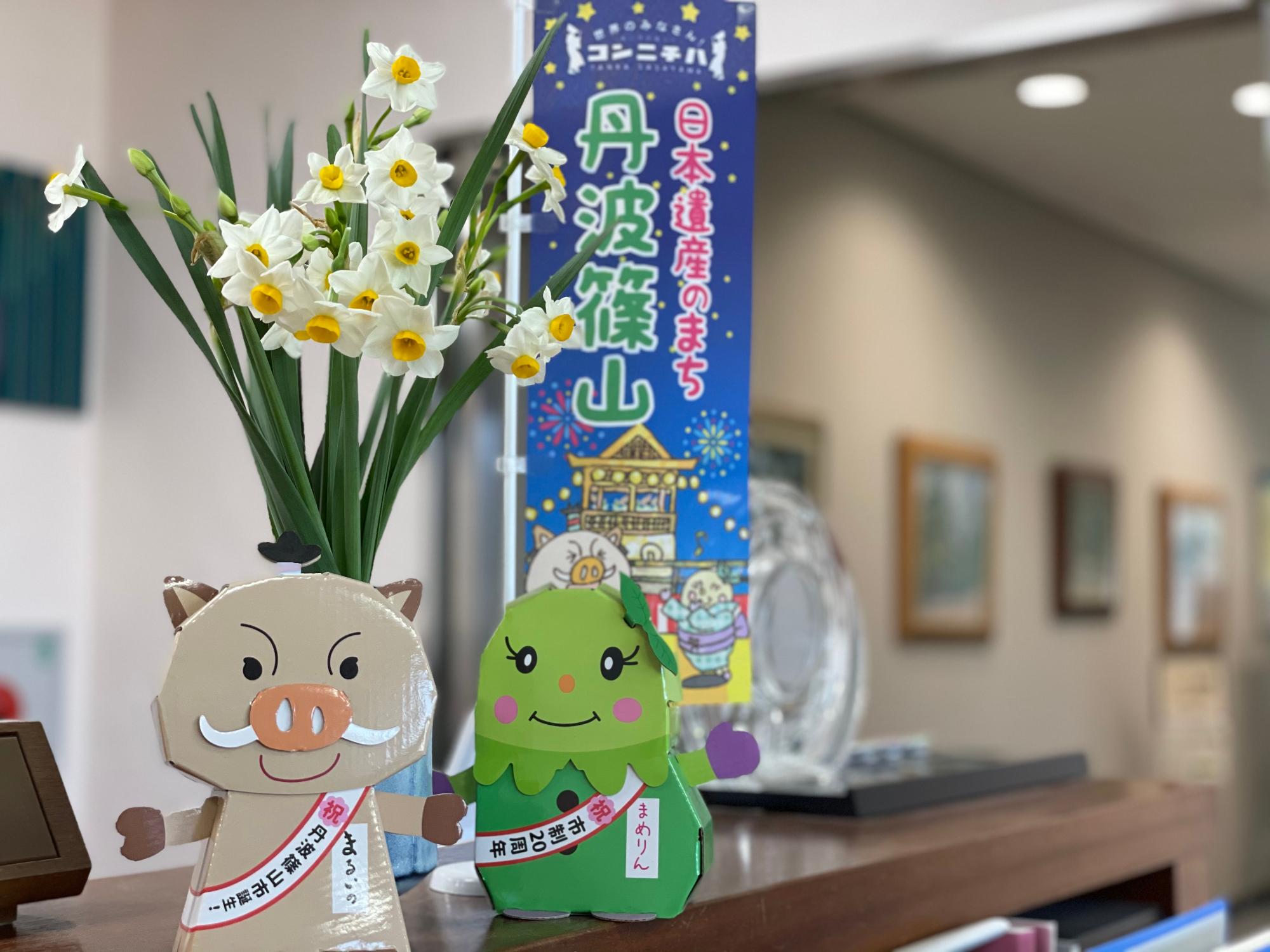 まるいのまめりんの貯金箱と一緒に花瓶に生けた越前水仙の写真。