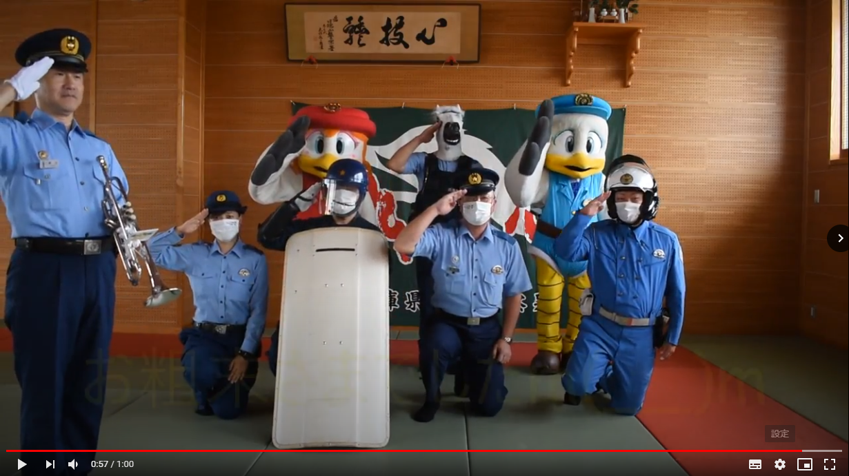 署長、次長、白バイ隊員、機動隊員、美人警官、馬の被り物をした隊員、マスコットキャラクターが敬礼している