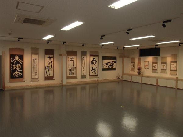 壁に掛けられた13もの作品を引きで撮っている写真