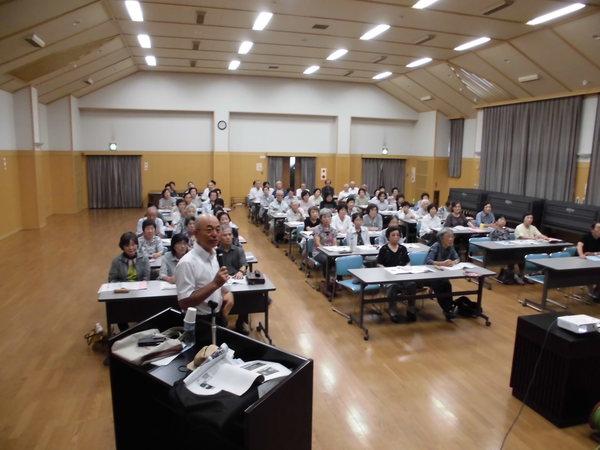 市長が高齢者大学に訪問し生徒の前でマイクを持ってお話ししている写真