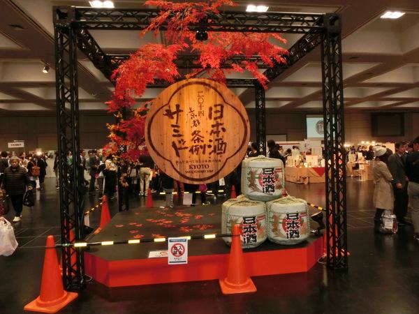 日本酒条例サミットin京都の会場でモミジの木に看板が付けられており日本酒の樽がディスプレイされている写真