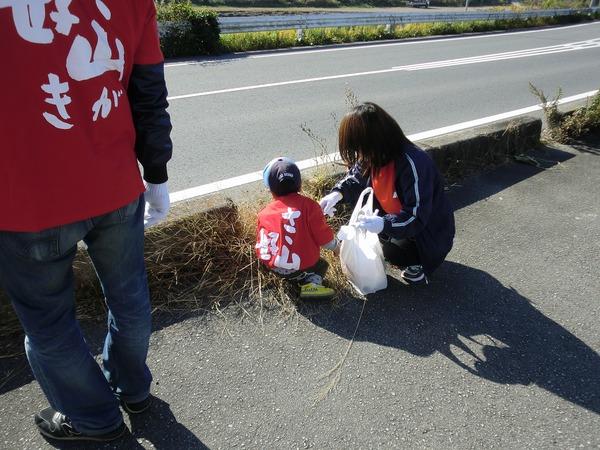小さい男の子とお母さんが道路に落ちているごみを拾っている様子の写真