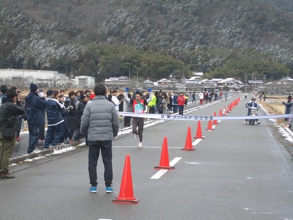 沢山の観客が見守る中、両手を挙げた選手が、ゴールにむかって走っている写真