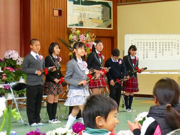 卒業生の女の子が卒業証書を持って歩いてる写真