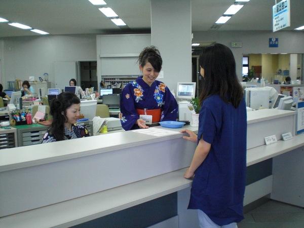 浴衣を着て、窓口の対応をする女性職員の写真