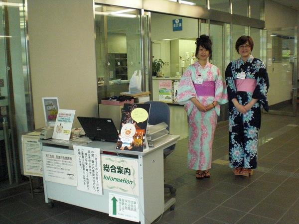 総合案内の机の横に立つ、2名の浴衣姿の女性職員の写真