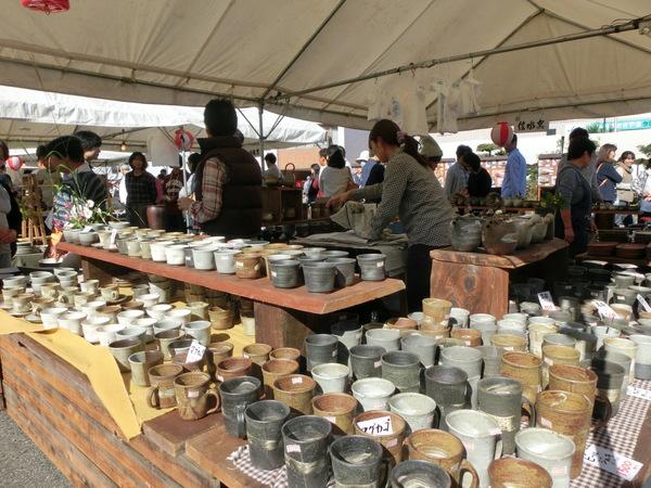 テントの中で沢山の丹波焼陶器が並べられている写真