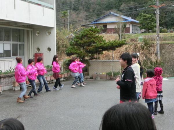 ピンクのジャンパーを着た女性達が踊っている姿を子供達が楽しそうに見ている写真