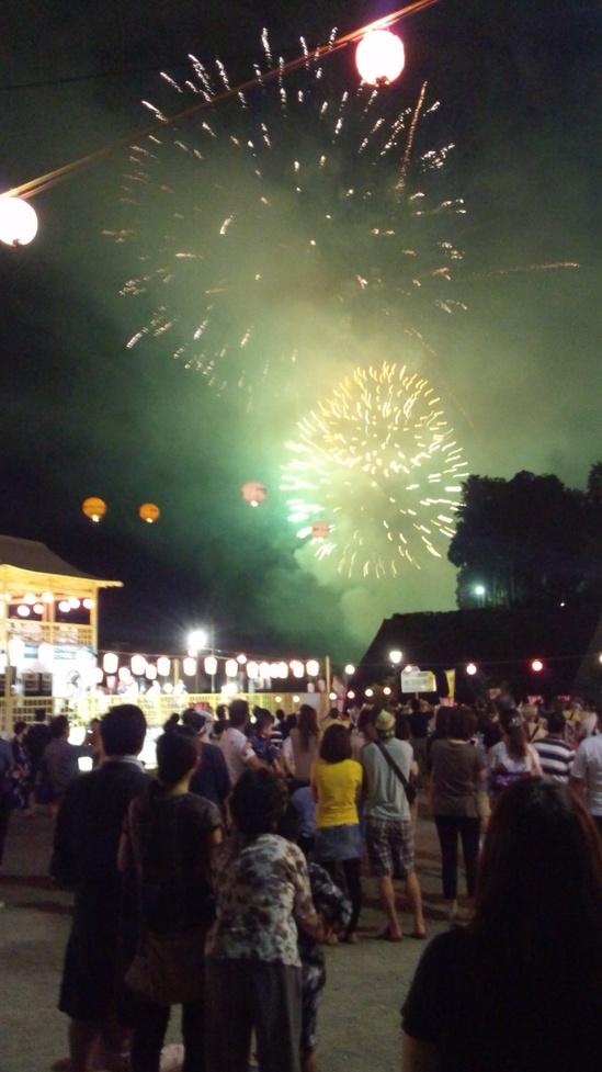 空に花火が上がりみんな立ち止まって見ている写真