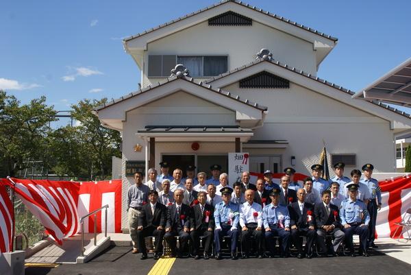 新築された畑駐在所の前で警察官や市長らが記念撮影している写真