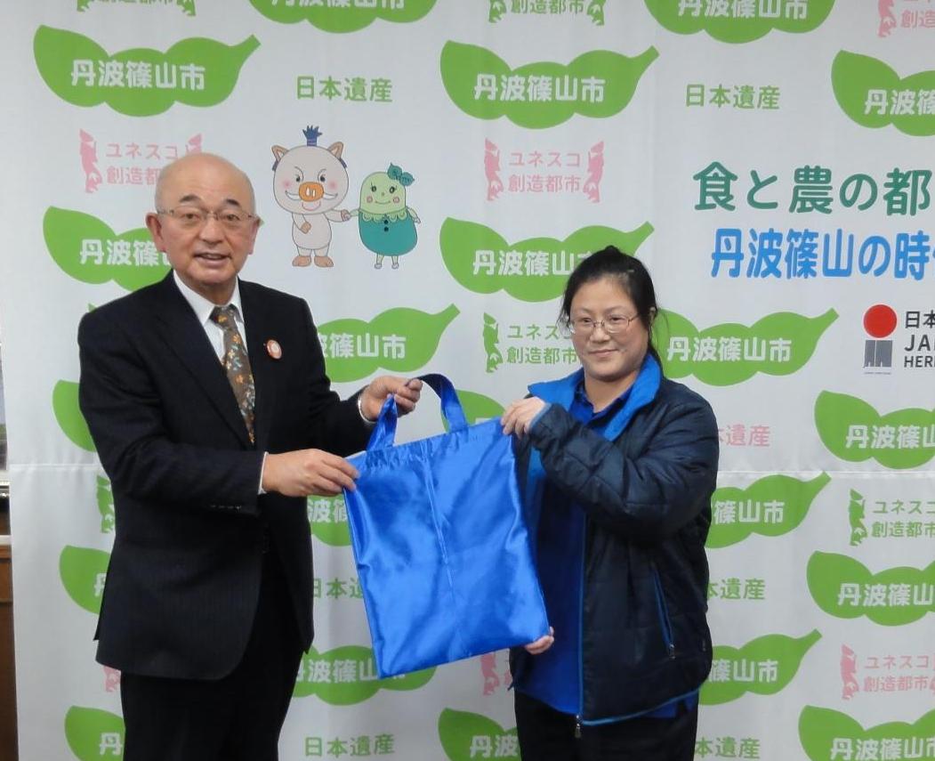 PTA代表の方からエコバッグを受け取る酒井市長