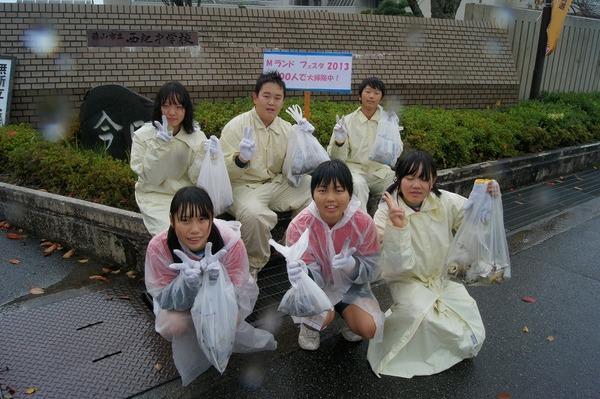 カッパを着た参加者6名が、自分で広い集めたごみ袋を見せながらの記念撮影