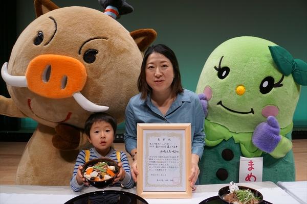 イメージキャラクターと西嶋 大恵くんが篠山八宝丼を持ち、西嶋 咲子さんが賞状を持って記念写真
