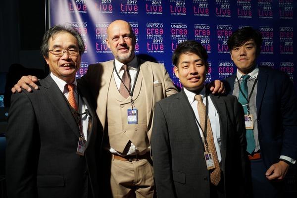 グレゴワール・ペナヴェール氏（アンギャンレバン副市長）が両脇の男性の肩に手をおき男性4人で一緒に記念撮影写真