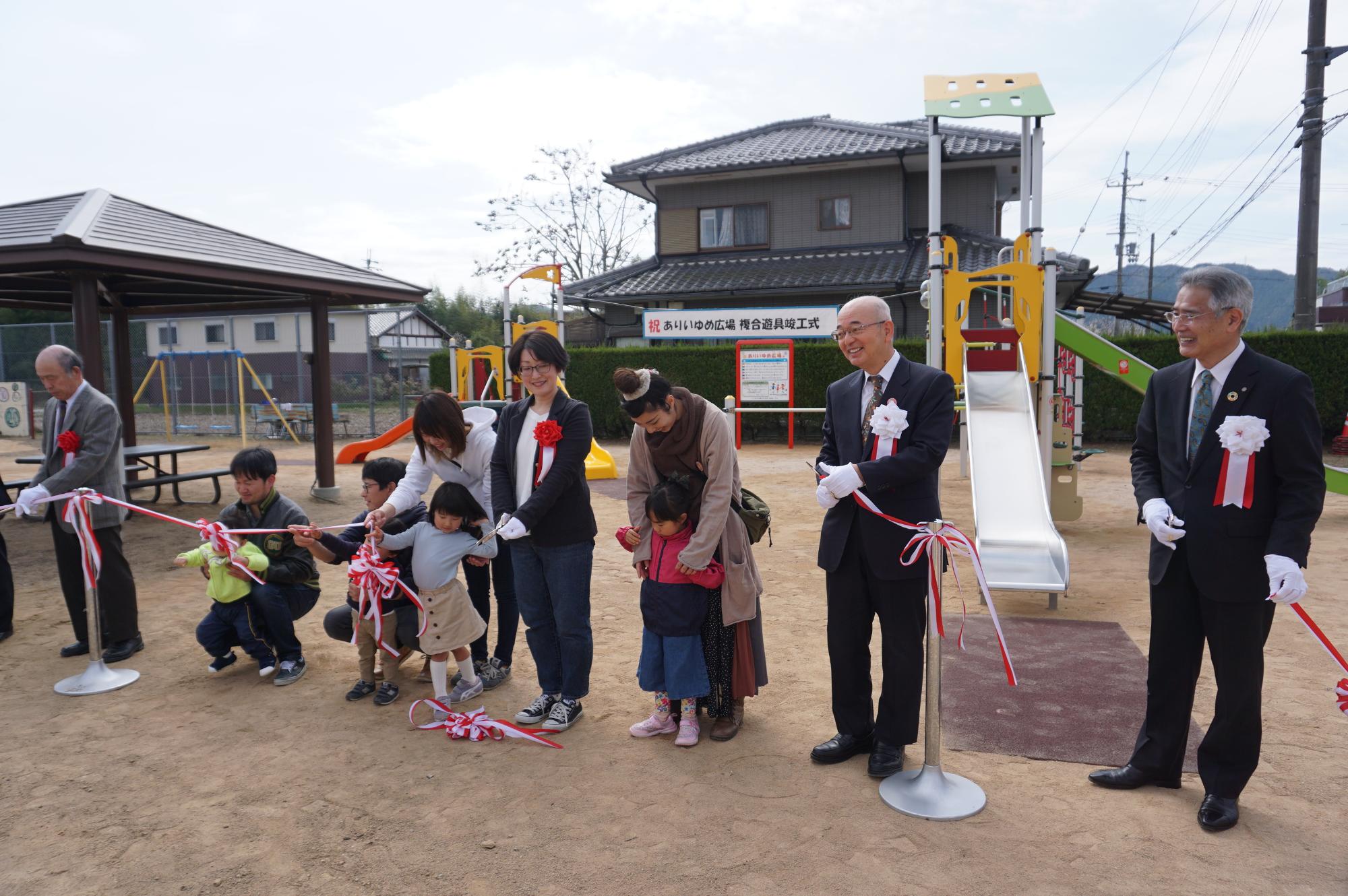 関係者と地域の子どもたちも一緒にテープカットをしている