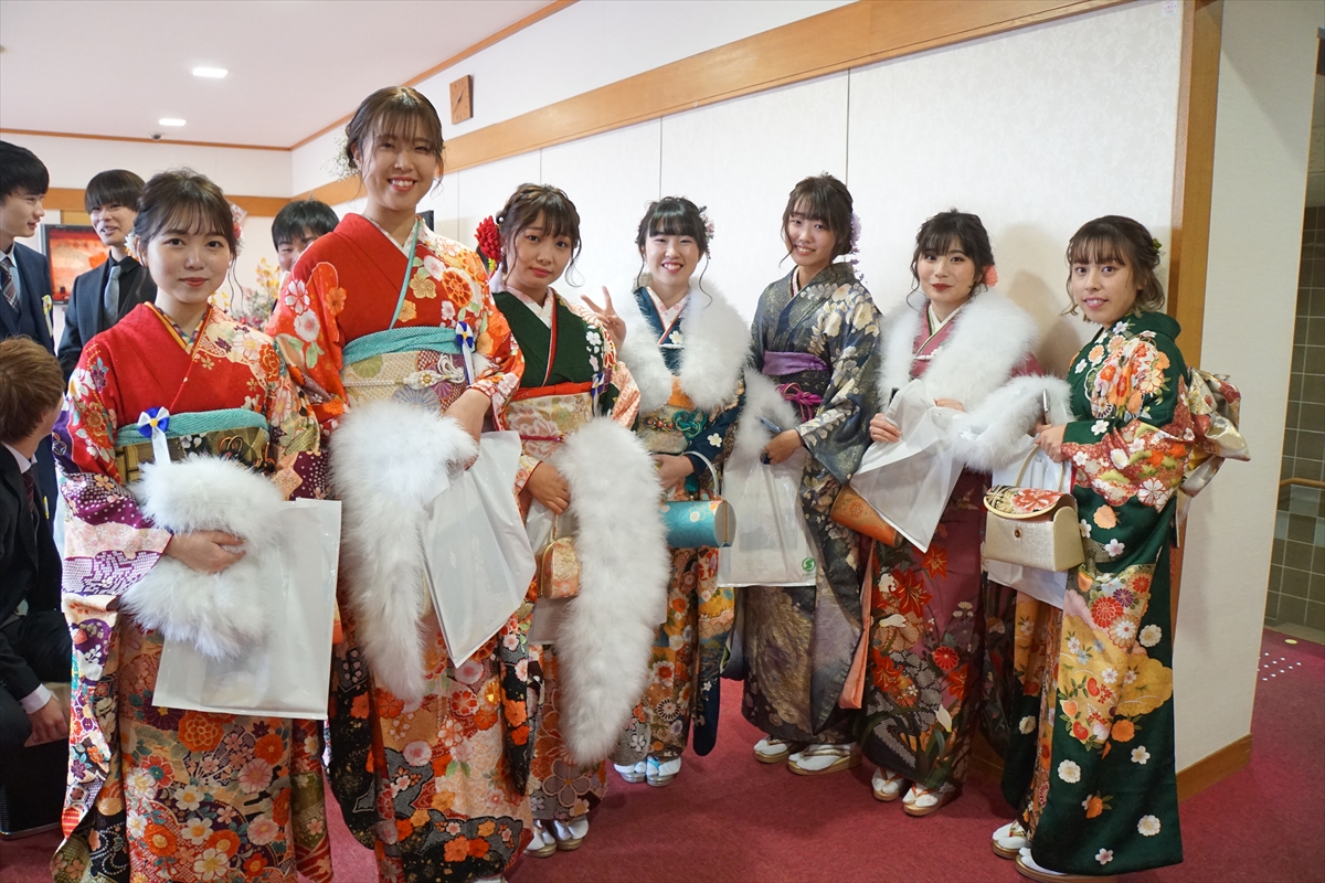 赤や緑などの振袖を着た7人の女性の新成人（田園交響ホールのロビーにて）