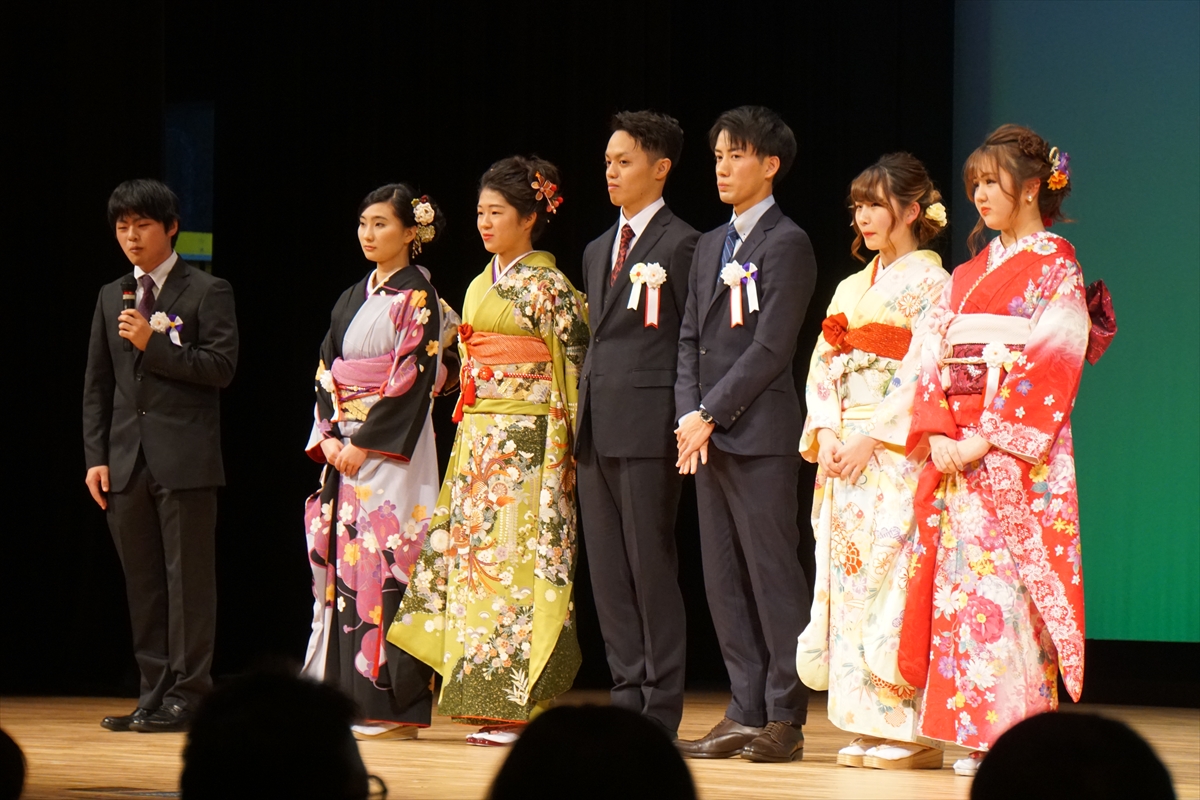 田園交響ホールの舞台の上で4人の女性と3人の男性の新成人が立っている