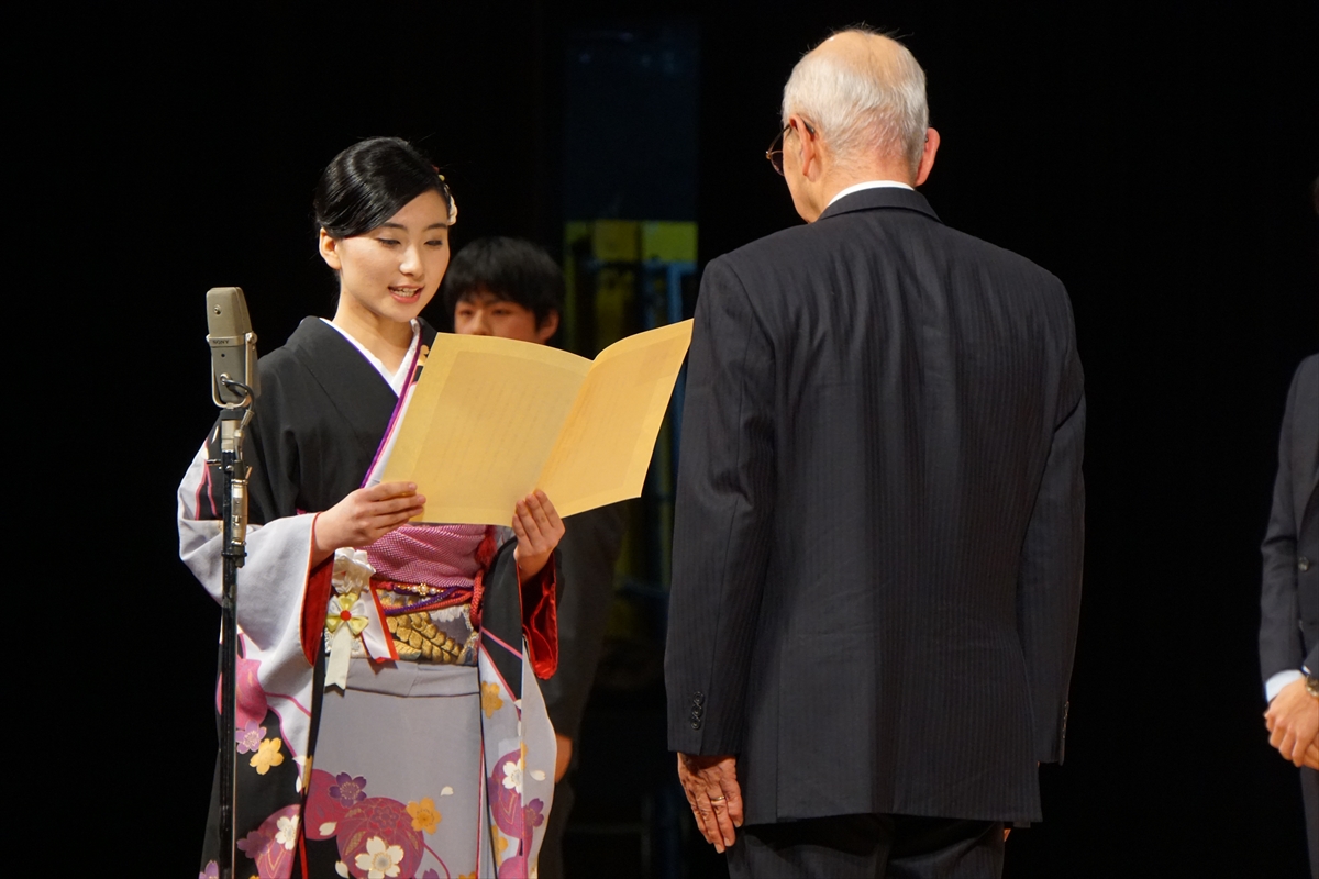 黒色の振袖を着た新成人と市長の後ろ姿