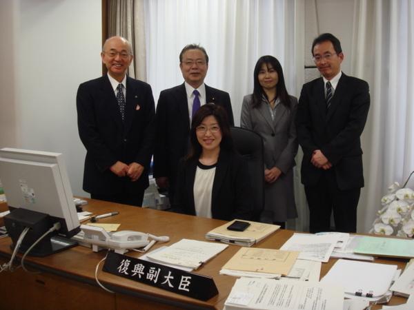 谷公一副大臣が座っていて、市長と男性2人と女性の5人で記念写真