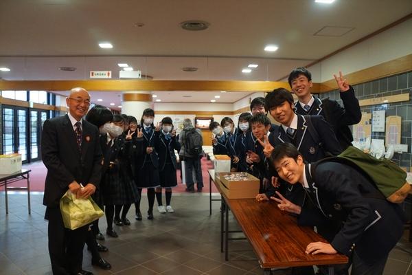 市長と制服を着た学生が列になって記念写真