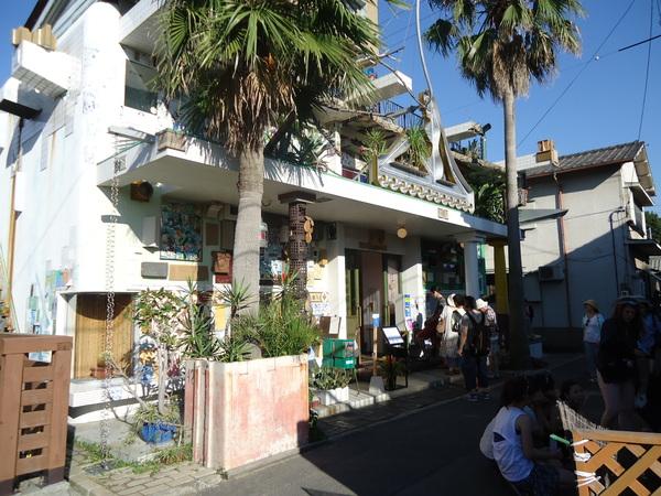 ヤシの木が入り口にあり、壁にたくさんの装飾が施されている銭湯の入口の写真