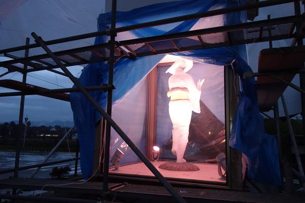建設中のモニュメントにライトアップされているデカンショ人形の写真