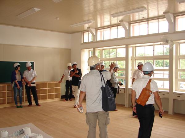 内装が完成している教室で、校庭や室内を見ている関係者の写真