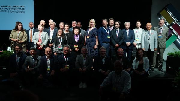 10名ほどの人達が座っていて、その後ろに20名ほどの人達が立っている集合写真