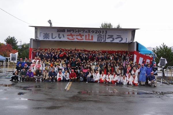 「楽しいささ山創ろう」の横断幕の前で参加者全員で記念撮影
