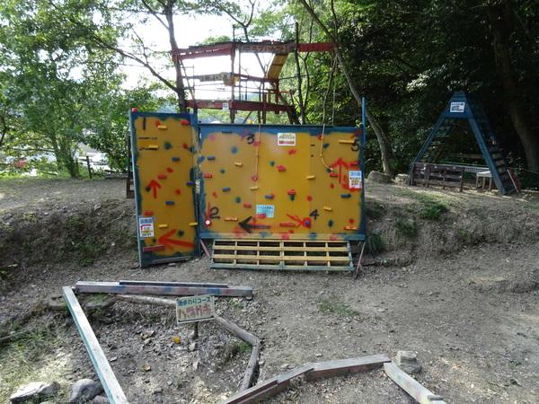 大きない黄色にぬられた鉄板のあちらこちらに、長方形の物が貼り付けられた、手作りのロッククライミングの写真