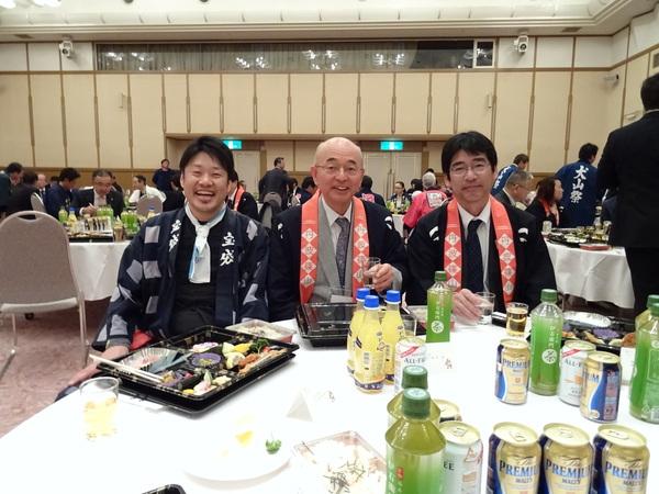 法被姿の市長と山田犬山市長が円テーブルに座り、手にはコップを持ち記念写真