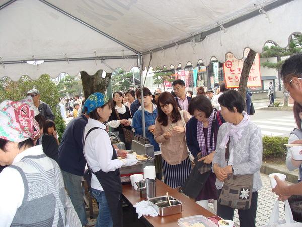 とろろ汁、とろろ揚げの販売所で会計をされる方の写真