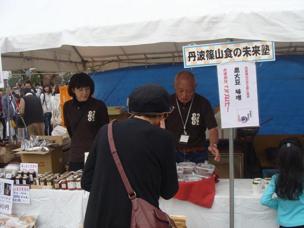 丹波篠山食の未来塾さんの商品を販売する男性と買われる女性の写真