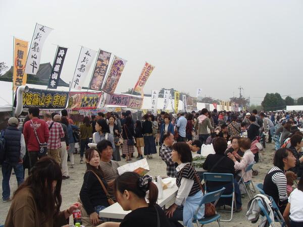 牛串、たこ焼き、からあげの出店が並んでいて、沢山のお客さんが買い求めている写真