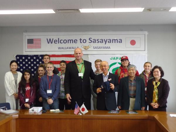 ようこそ篠山と英語で書かれたところに並ぶ市長と、外国人男女の集合写真