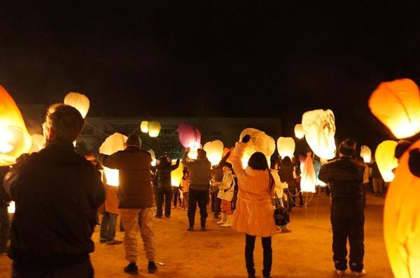 参加者たちがランタンを飛ばそうと手に持っている写真