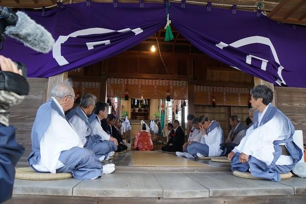 神社の中に袴姿の男性が座っておりお祓いが行われている写真