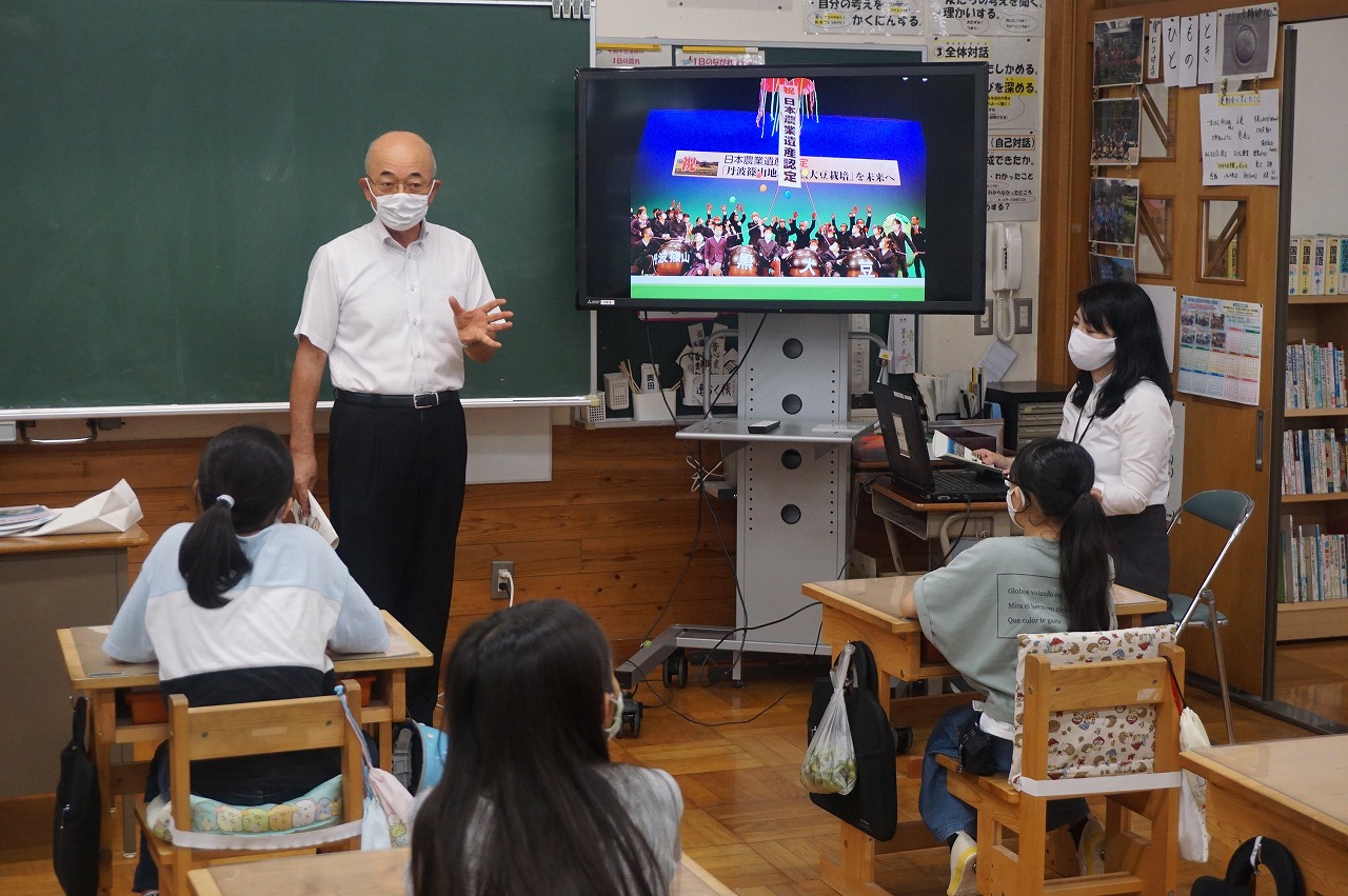 市長がモニターを使って子どもたちに日本農業遺産のことを説明している。