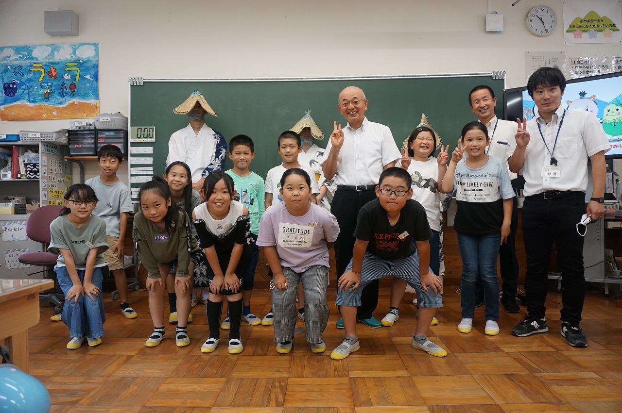 市長や先生、子ども達が黒板の前に並んで記念撮影している。