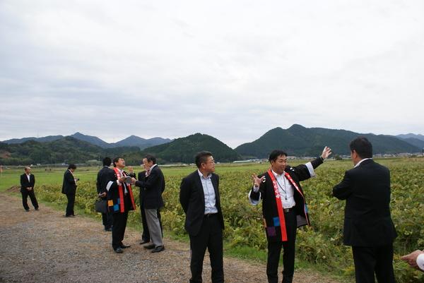 法被を着た男性が来場者に土地を説明している写真