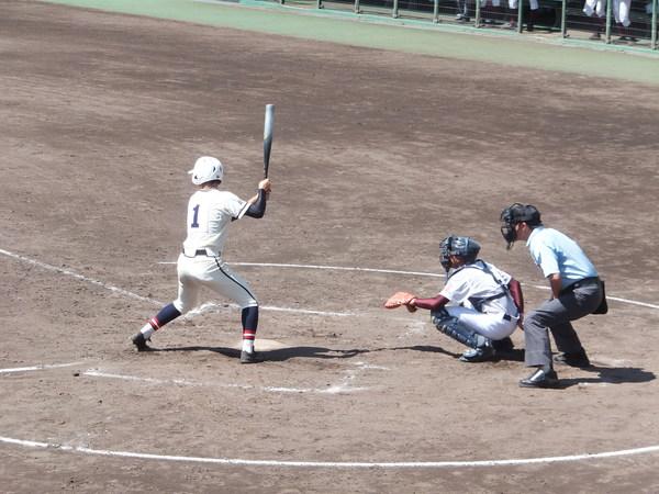 1番背番号のバッターが、ボールを打とうと構えている写真