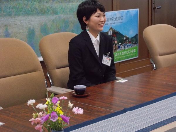 細見 安里（あんり）さんが、お話しをしている机にお花が飾られている写真