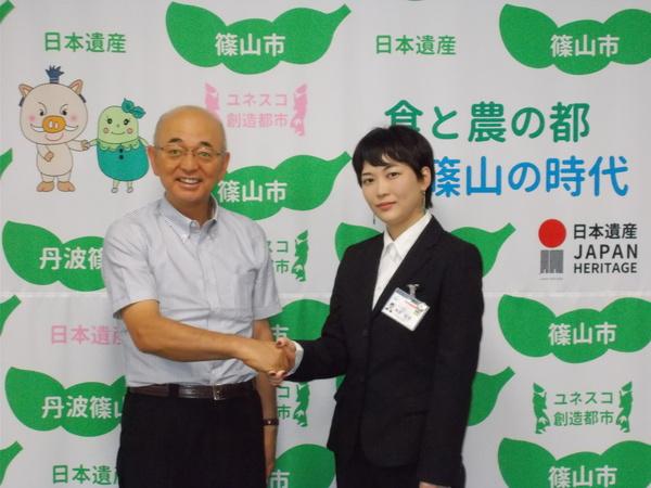 細見 安里（あんり）さんと市長が握手をしながら記念撮影写真