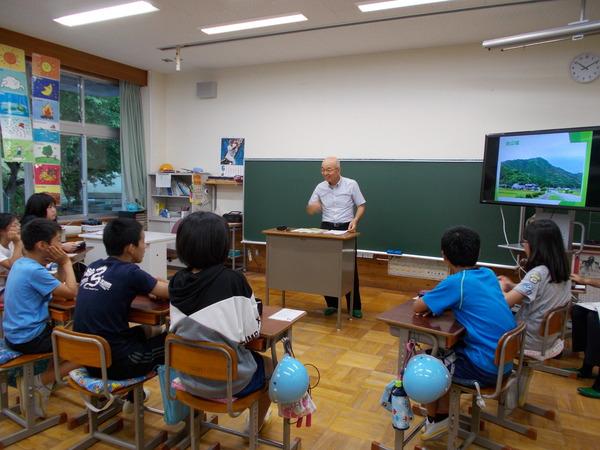 教室の中で市長が笑顔で子供たちに授業をしている写真