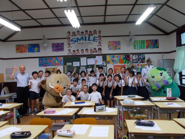 市長とマスコットキャラクターが八上小学校の生徒たちと笑顔で記念撮影写真