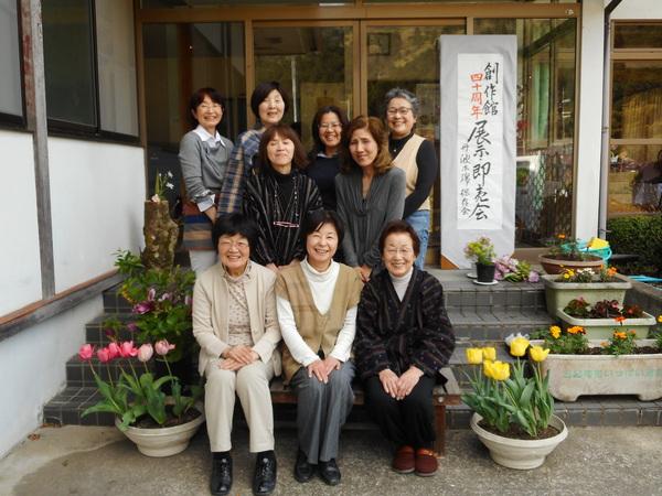 出入り口の階段に並ぶ複数の笑顔の女性の写真