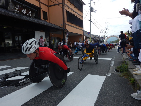 車いすマラソンで選手が沿道を走っている