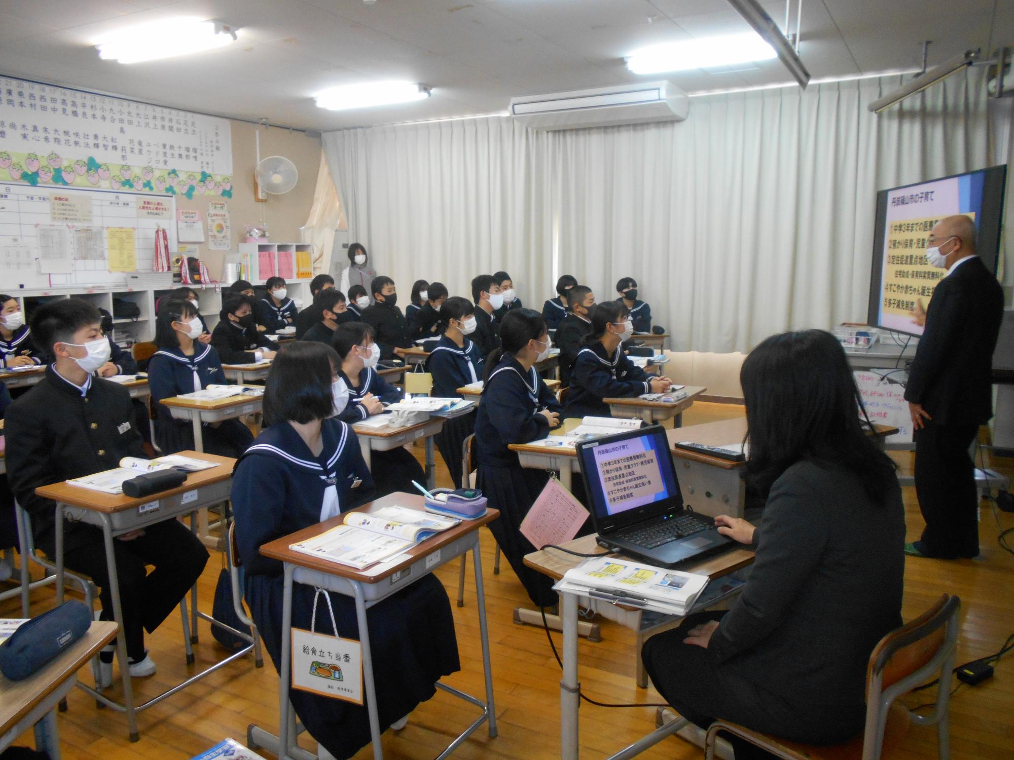市長が中学生たちに教室で授業をしている。