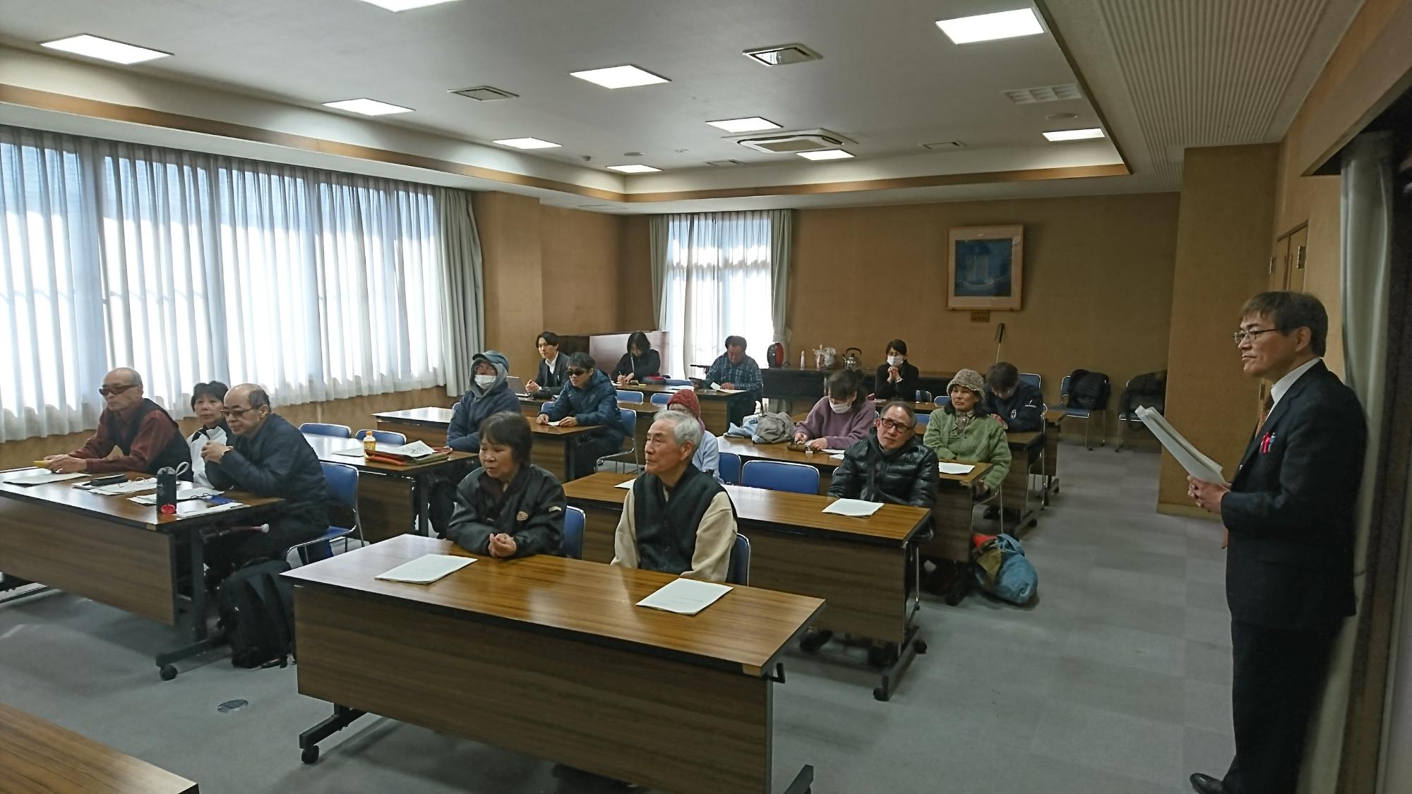 縦に5列、横に2列机が並んでおり、参加者の方々がイスに座って話を聞いている会場全体の写真